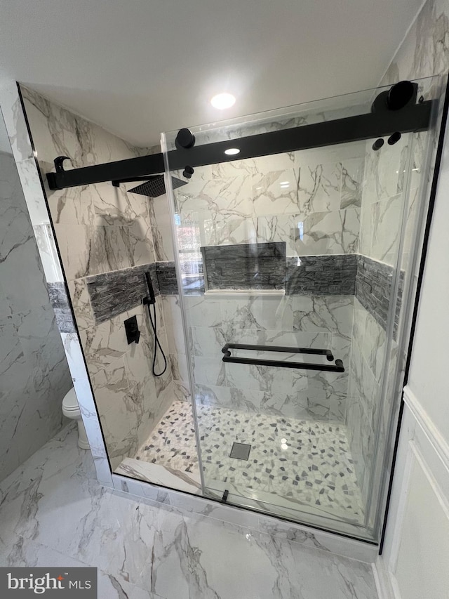 bathroom with toilet, marble finish floor, a marble finish shower, and stone wall