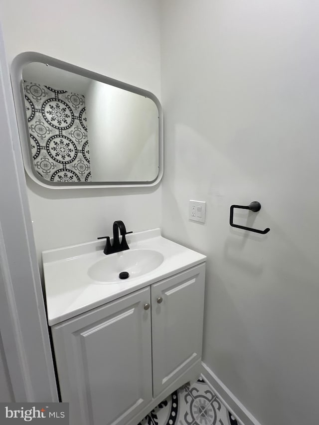 bathroom with tile patterned flooring, baseboards, and vanity