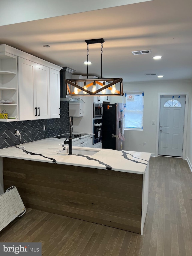 kitchen featuring a peninsula, dark wood-type flooring, white cabinetry, appliances with stainless steel finishes, and open shelves