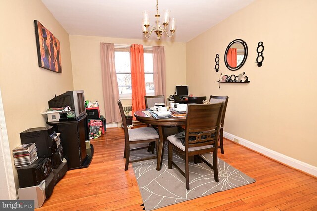 dining space with a chandelier and light wood-type flooring