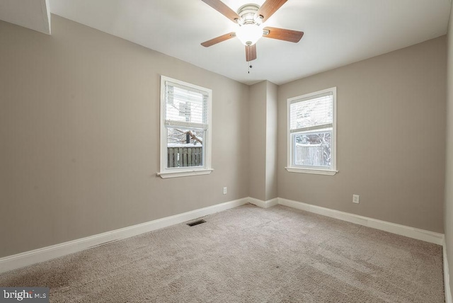 empty room with carpet floors, plenty of natural light, and ceiling fan