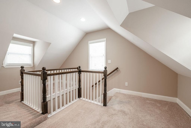 bonus room with light carpet and vaulted ceiling