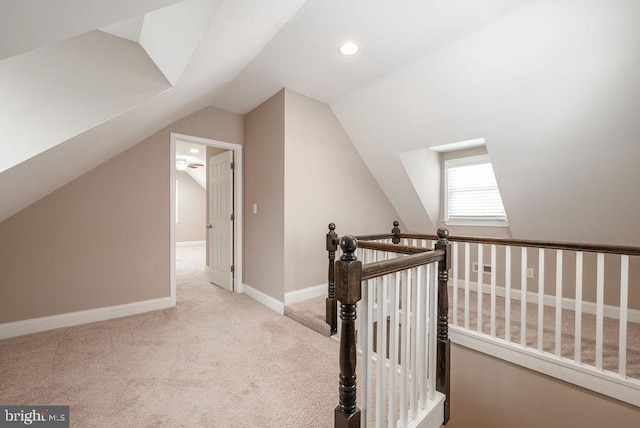 additional living space with light colored carpet and vaulted ceiling