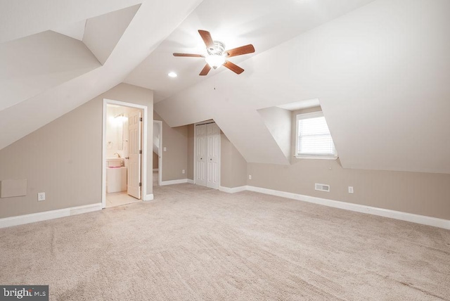 additional living space with ceiling fan, light colored carpet, and vaulted ceiling