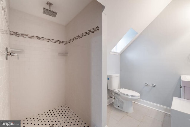 bathroom with toilet, vanity, and tiled shower