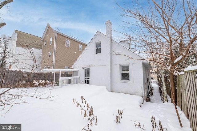 view of snow covered back of property