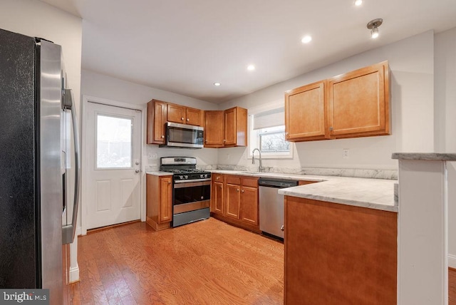 kitchen featuring appliances with stainless steel finishes, light hardwood / wood-style floors, and sink