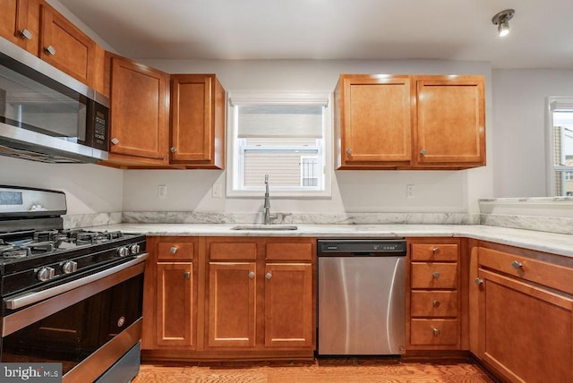 kitchen featuring appliances with stainless steel finishes, light wood-type flooring, and sink