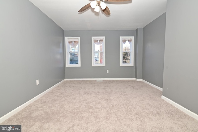 unfurnished room with ceiling fan and light carpet