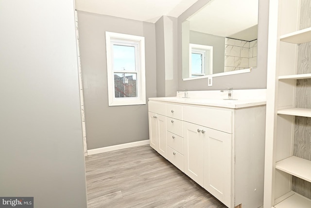 bathroom with vanity, a healthy amount of sunlight, and wood-type flooring