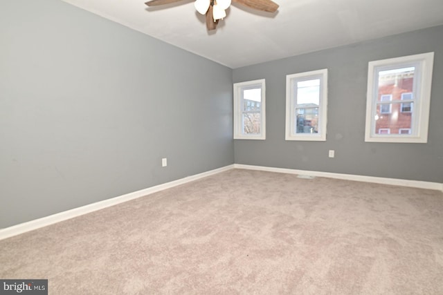 carpeted spare room with ceiling fan