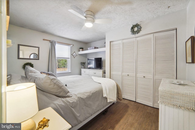 bedroom featuring dark hardwood / wood-style flooring, a closet, ceiling fan, and a textured ceiling