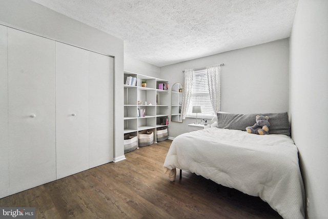 bedroom with a textured ceiling, hardwood / wood-style floors, and a closet