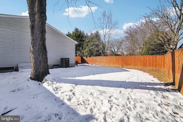 yard layered in snow featuring central air condition unit