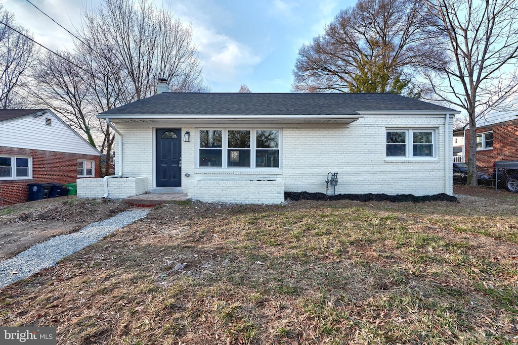 view of front of home with central AC and a front lawn