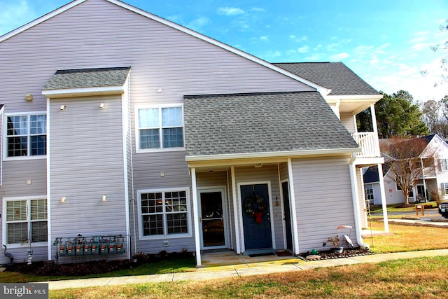 back of house with a yard and a balcony