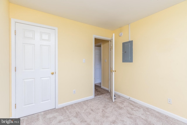 unfurnished bedroom with electric panel and light colored carpet