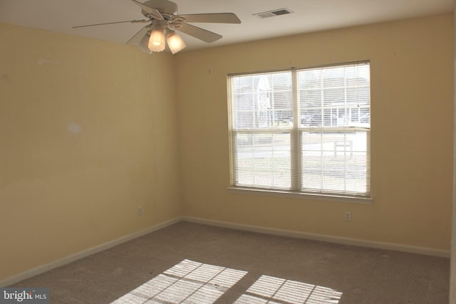 unfurnished room with ceiling fan and carpet