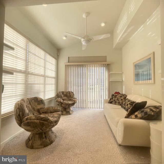 carpeted living room featuring ceiling fan and lofted ceiling