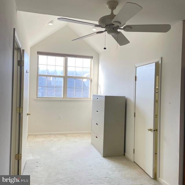 unfurnished bedroom featuring ceiling fan, light colored carpet, and vaulted ceiling