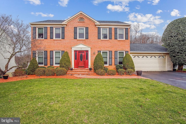 colonial inspired home featuring a front yard and a garage