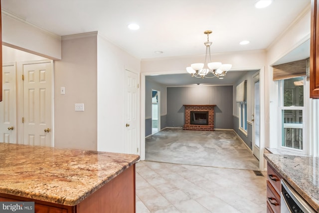 kitchen with a brick fireplace, light stone counters, hanging light fixtures, and a notable chandelier