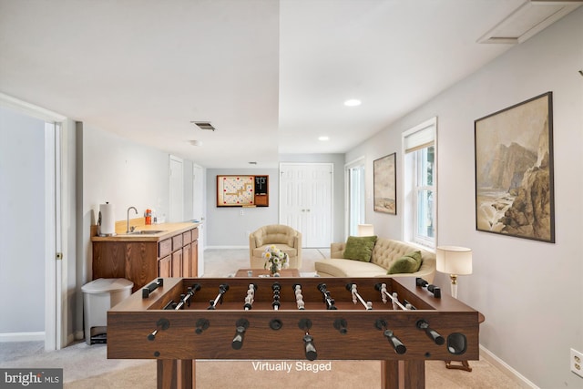 rec room with light carpet and sink