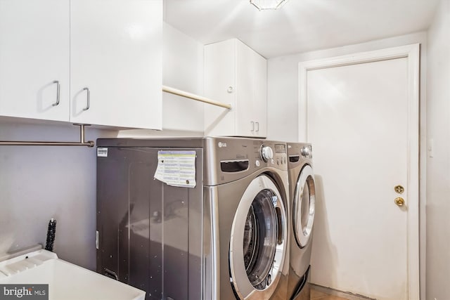 laundry room with washing machine and dryer and cabinets