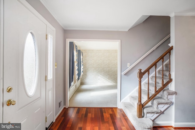 entrance foyer with dark hardwood / wood-style flooring and ornamental molding