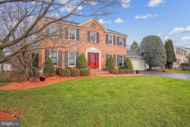 colonial-style house with a garage and a front yard