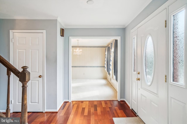 foyer entrance with hardwood / wood-style flooring, a notable chandelier, and crown molding