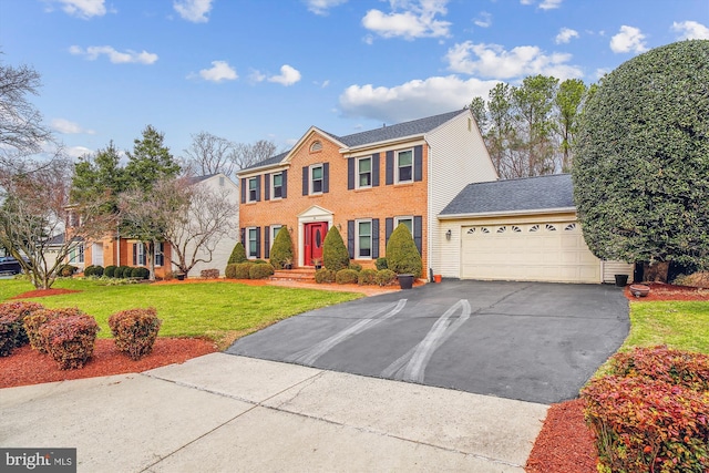 colonial home with a garage and a front lawn