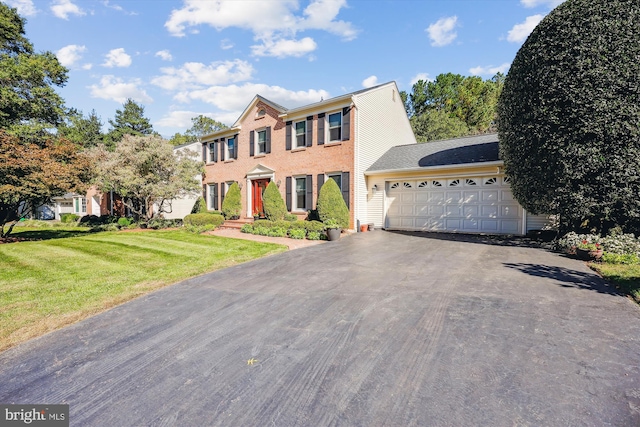 colonial house featuring a front yard and a garage