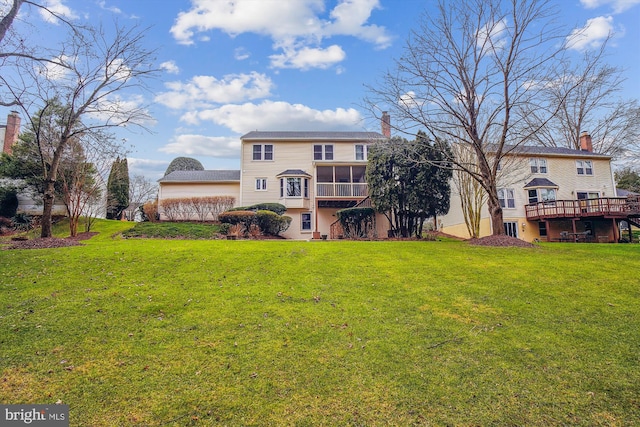 back of property featuring a sunroom, a yard, and a deck