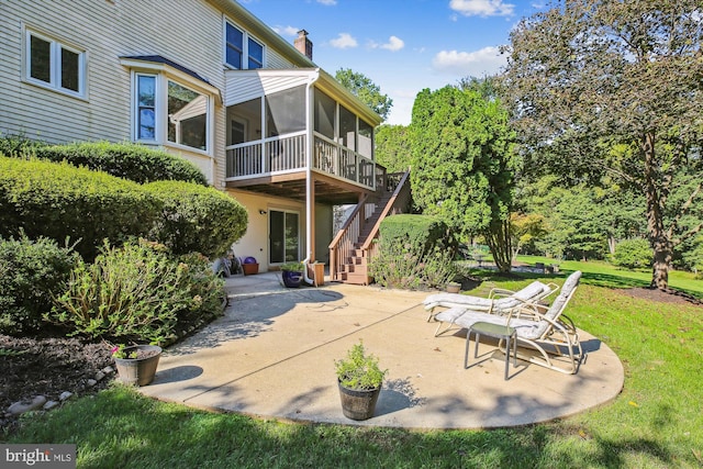 back of house featuring a lawn, a patio area, and a sunroom