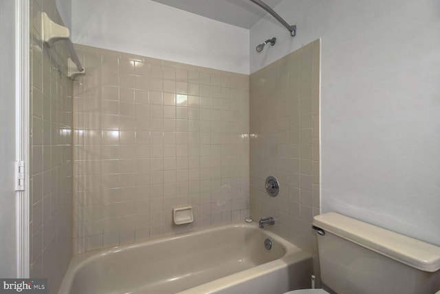 bathroom featuring tiled shower / bath combo and toilet