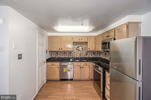 kitchen featuring sink, decorative backsplash, light brown cabinetry, appliances with stainless steel finishes, and light hardwood / wood-style floors