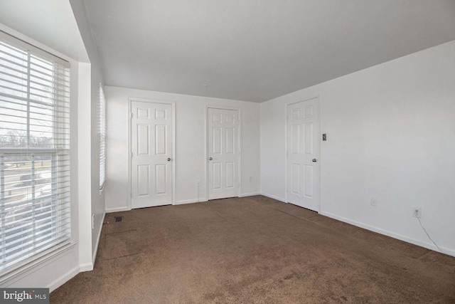 unfurnished bedroom featuring dark carpet