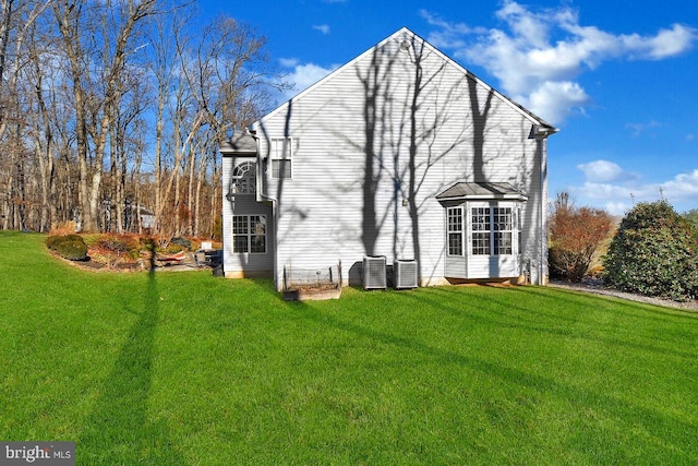 back of house with a lawn and central AC unit