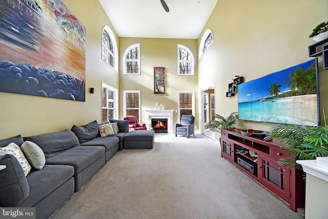 living room with carpet, a high ceiling, and ceiling fan