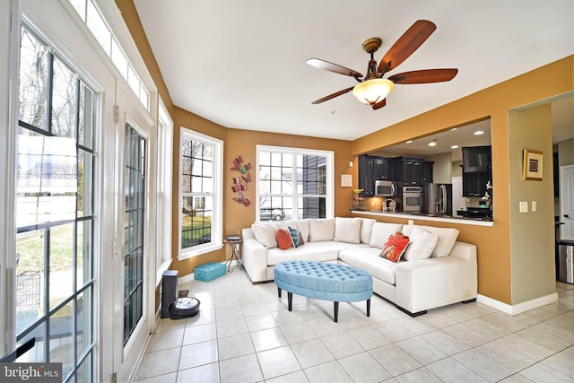 tiled living room featuring ceiling fan and a healthy amount of sunlight