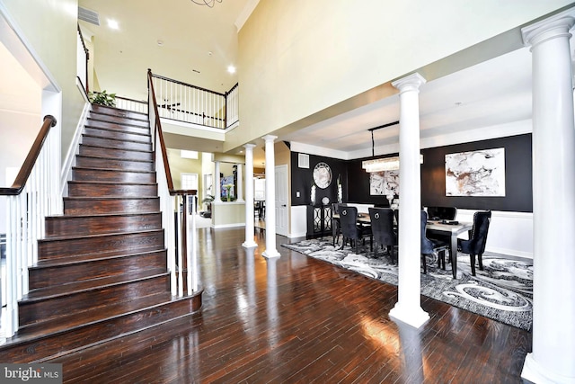 entrance foyer with a notable chandelier, wood-type flooring, and a high ceiling