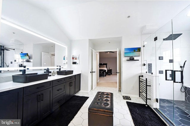 bathroom with ceiling fan, vanity, a shower with shower door, and lofted ceiling