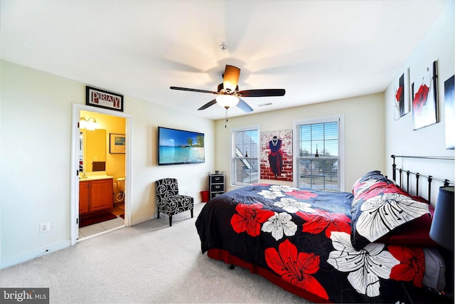 bedroom featuring light carpet, connected bathroom, and ceiling fan