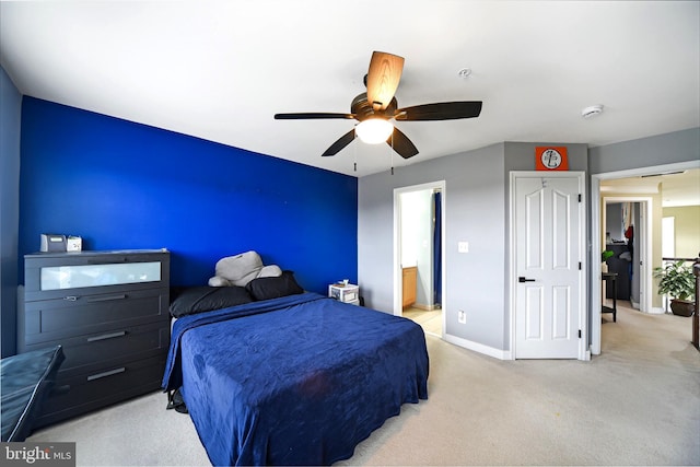 carpeted bedroom featuring ensuite bathroom and ceiling fan