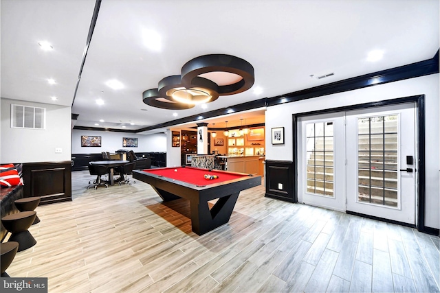 rec room with indoor bar, light hardwood / wood-style floors, and pool table