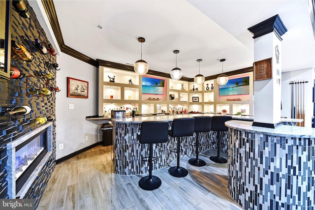 bar featuring decorative light fixtures and ornamental molding