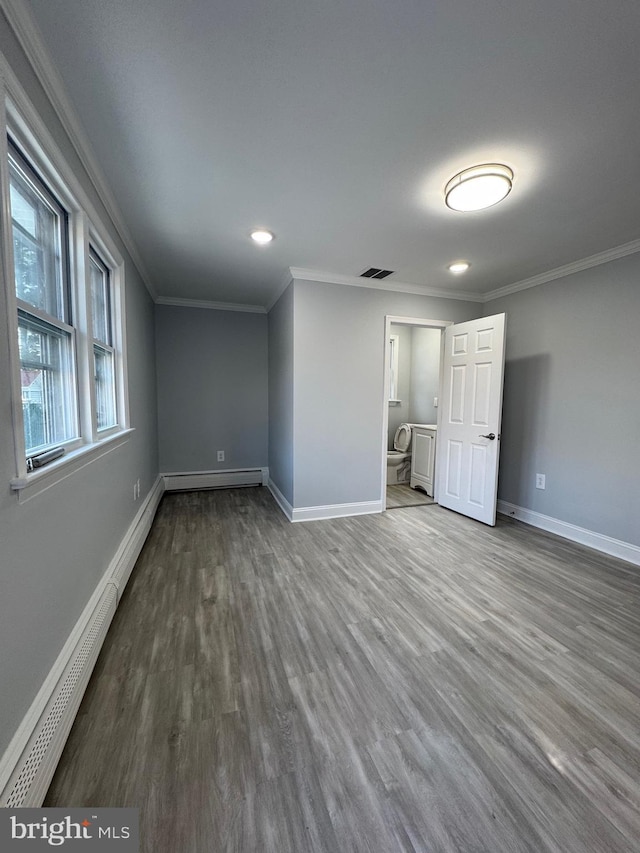 empty room featuring wood-type flooring, a baseboard radiator, and crown molding