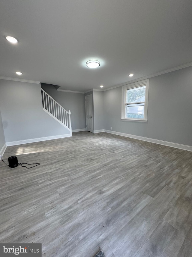 basement with ornamental molding and hardwood / wood-style flooring