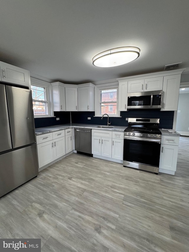 kitchen featuring white cabinets, stainless steel appliances, and sink